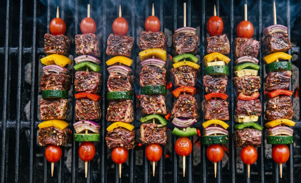 Delicious steak and veggie kabobs cooking over a hot grill, featuring beautiful brown sear marks and slightly blistered bell peppers.
